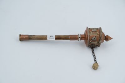 a small metal object on a chain on a white surface