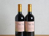 deux bouteilles de vin posées l'une à côté de l'autre sur une table en bois