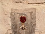 a glass vase with a red flower in it on a table