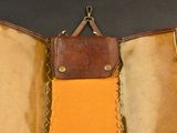 an open suitcase with a brown leather handle and a tan lining