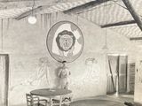 an old photo of a man standing in front of a painting on a wall