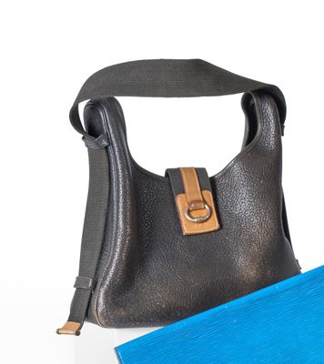 un sac à main noir et une serviette bleue posés sur une surface blanche