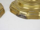 two golden candles that are sitting on a white table