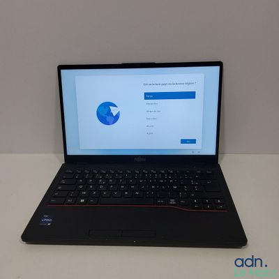 L'ordinateur portable est posé sur la table, l'écran ouvert.