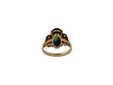 an image of a gold ring with a green stone