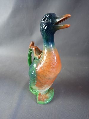 a colorful duck figurine sitting on a gray surface