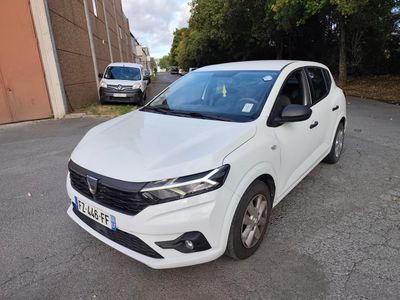 une voiture blanche garée dans un parking à côté d'un bâtiment