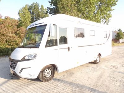 un petit camping-car blanc garé sur un parking