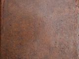 an old book with a leather cover sitting on top of a wooden table