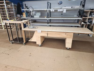 a workbench in the middle of a room with a lot of shelves