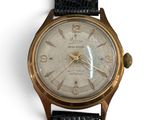 a close up of a gold wrist watch on a white background
