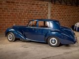 a blue car parked in a garage next to a brick wall
