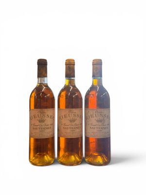 trois bouteilles de vin posées les unes à côté des autres sur une surface blanche