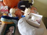 many stuffed animals sitting on a bed next to a box