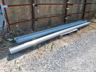 two pipes that are laying on the ground next to a fence
