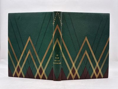 un vieux livre à la couverture verte et aux bordures dorées