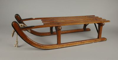 une vieille luge en bois à laquelle est attachée une corde