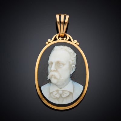 un portrait en marbre blanc représentant un homme portant un nœud papillon, dans un cadre doré