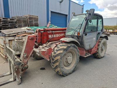 un tracteur rouge garé devant un bâtiment