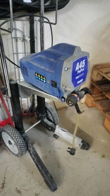 a picture of a man using a power washer in a garage