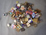 a pile of assorted badges on a table