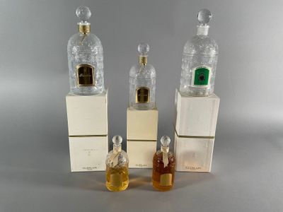 three bottles of perfume sitting next to each other on top of boxes