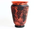 a red vase with black designs on it on a white background