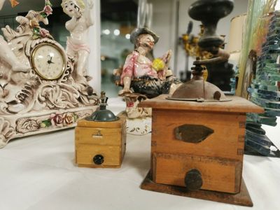 Plusieurs figurines sont posées sur une table où se trouvent également une horloge et une boîte