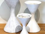 three white vases sitting on a table next to each other