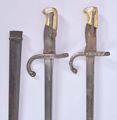 two old swords are displayed on a white surface with a white background