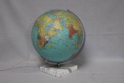 a blue and green globe on a stand with a white base