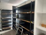 de nombreuses étagères vides dans un magasin, sur lesquelles se trouvent quelques articles
