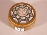 a small round box with a decorative design on it