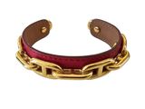 a close up of a red leather bracelet with gold chains