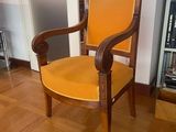 a wooden chair with a yellow seat in a room