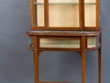 an old wooden display cabinet with glass shelves on top of it