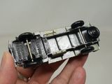 a hand holding a small toy train on a white surface