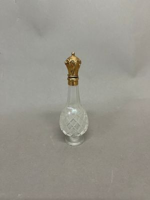 l'image d'une petite bouteille en verre surmontée d'une couronne dorée