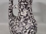 a black and white vase with a pink handle