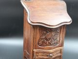 an old wooden cabinet with carvings on the front and a drawer on the back