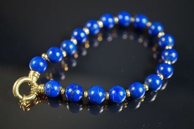 un gros plan sur un bracelet bleu muni d'un fermoir doré
