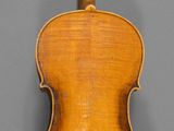 an old violin with a wooden back and bow on a gray background