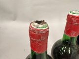 several bottles of wine are lined up on a white surface