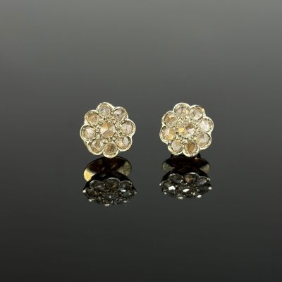 a pair of gold and diamond flower earrings