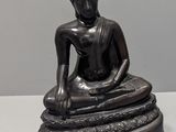 statue d'un Bouddha assis sur un rocher, sur un fond blanc