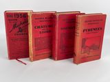 trois livres rouges posés les uns à côté des autres sur une surface blanche