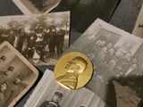 many old photos and a gold medal on a table