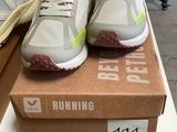 two pairs of running shoes sitting on top of a box on a table