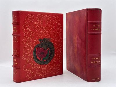 un vieux livre à la couverture rouge, sur laquelle est représentée une pomme