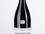 une bouteille de vin posée sur une table blanche